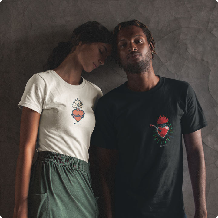 couple wearing bleeding heart zdropped t shirts in black and cream leaning against a grey wall