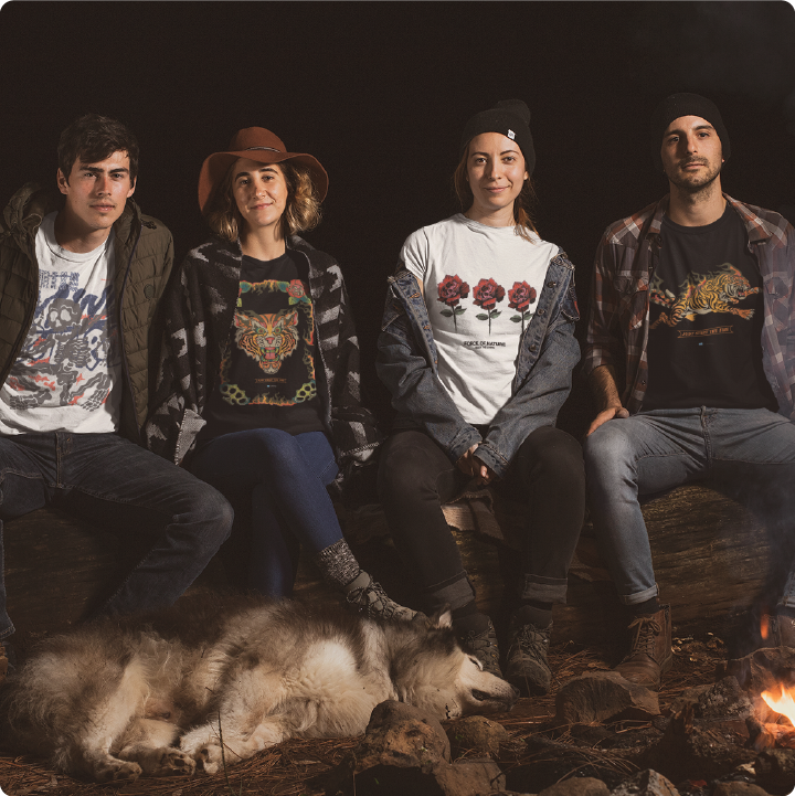 Four people sitting around a campfire with a wolf at night