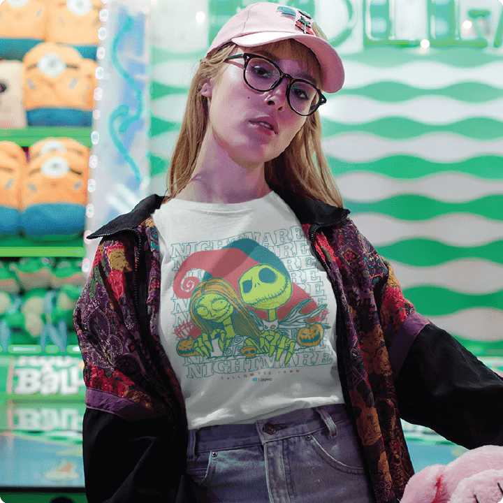 A young women wearing a white high waisted shirt with a colorful neon skeleton cartoon couple and 'Nightmare' text on a white background