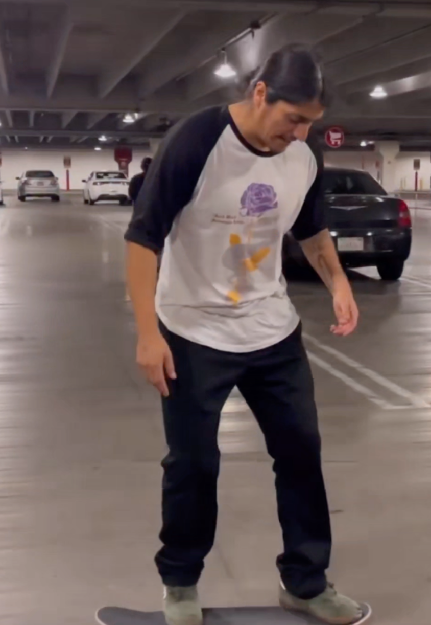 Pro Skateboarder Moose 805 aka Luis De los reyes skateboarding in a parking garage in the mamba quote raglan