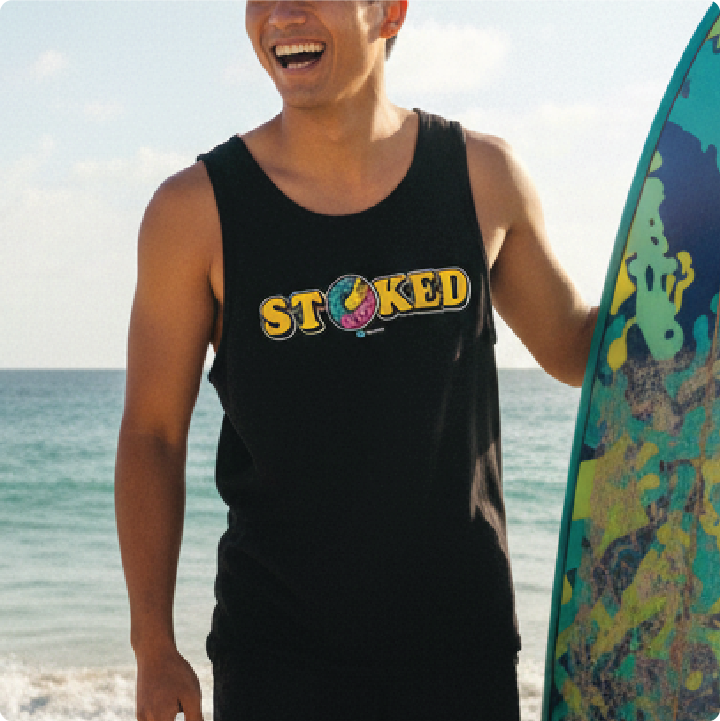 Surfer holding a surfboard in a black 'STOKED' tank top at the beach.