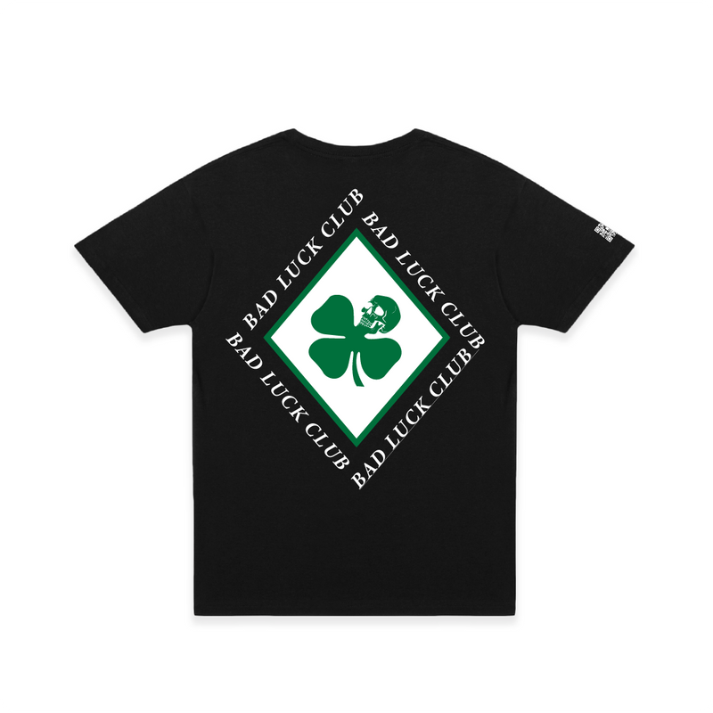 Rear view of a black crew neck t-shirt with a large green skull death clover diamond graphic and white 'Bad Luck Club' text.
