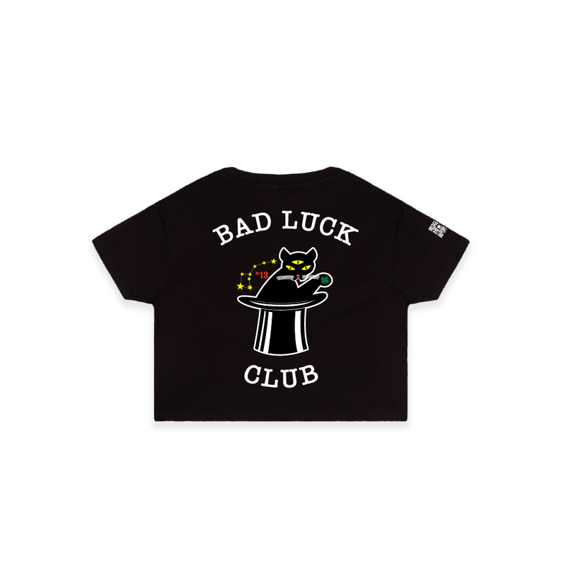 Rear view of a women's black crop top with 'BAD LUCK CLUB' text and a three eyed cat in a top hat.