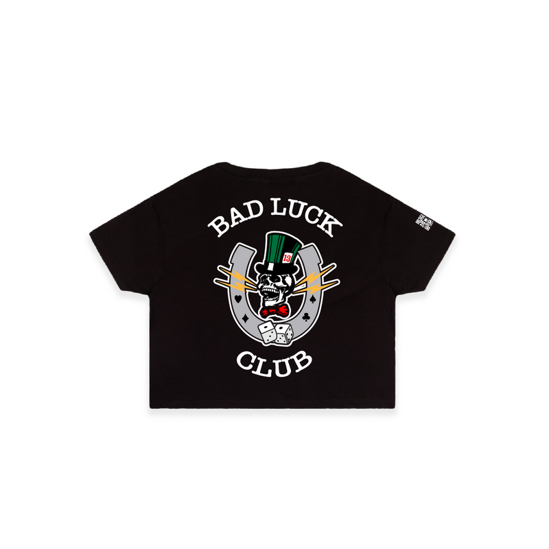 Rear view of a black crop top with white 'BAD LUCK CLUB' text and a large graphic in the center, featuring a skull and lightning bolts on a white background.