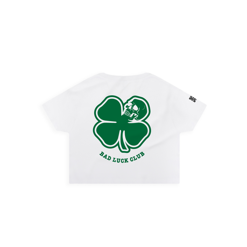 Rear view of a white crop top with a large green skull death clover graphic and the text 'BAD LUCK CLUB'.
