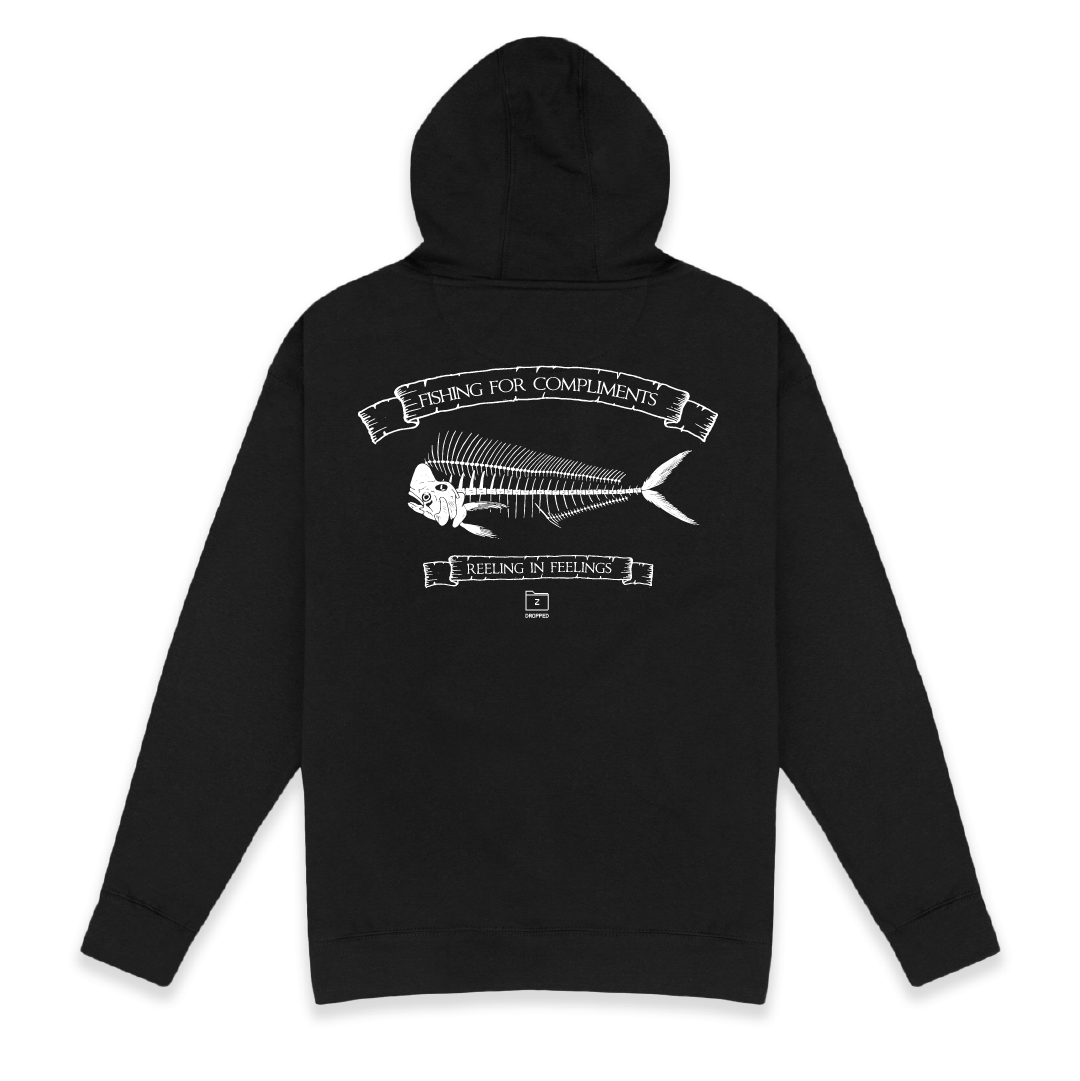 Rear view of a unisex black hoodie with large white mahi bones graphic on a white background with white text that reads "I'm the catch of the day" on the top of the fish graphic and "fishing for compliments" in white text below the graphic