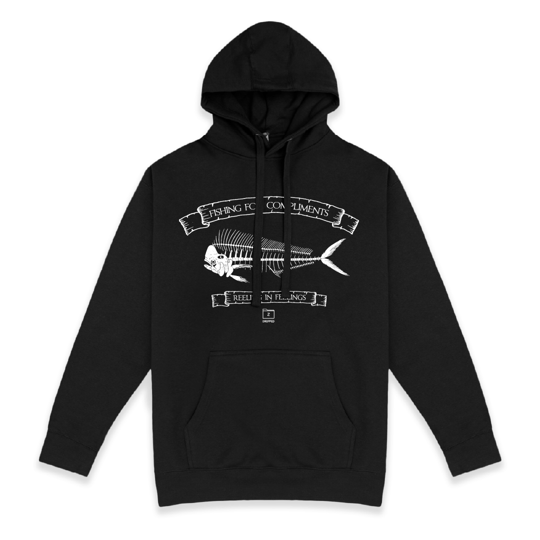 Front view of a unisex black hoodie with large white mahi bones graphic on a white background with white text that reads "I'm the catch of the day" on the top of the fish graphic and "fishing for compliments" in white text below the graphic