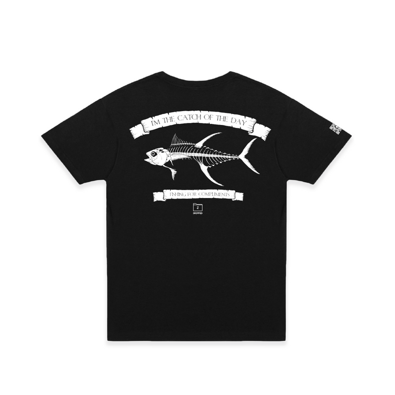 Rear view of a black t-shirt with large white tuna bones graphic and 'catch of the day' text on a white background