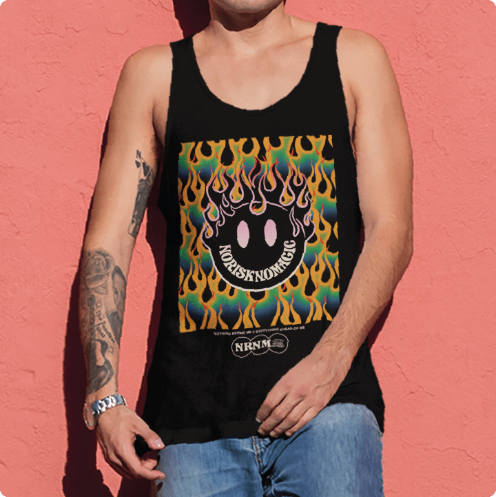 Person wearing a black zdropped flaming smiley face tank top with colorful design against a pink wall
