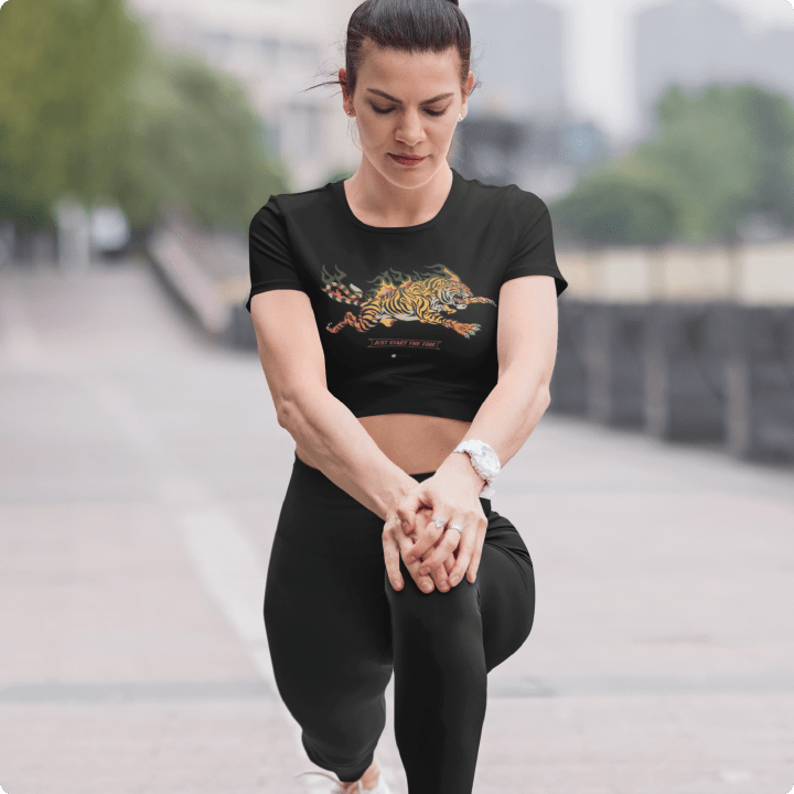 Woman wearing a black crop top t-shirt with a tiger design outdoors