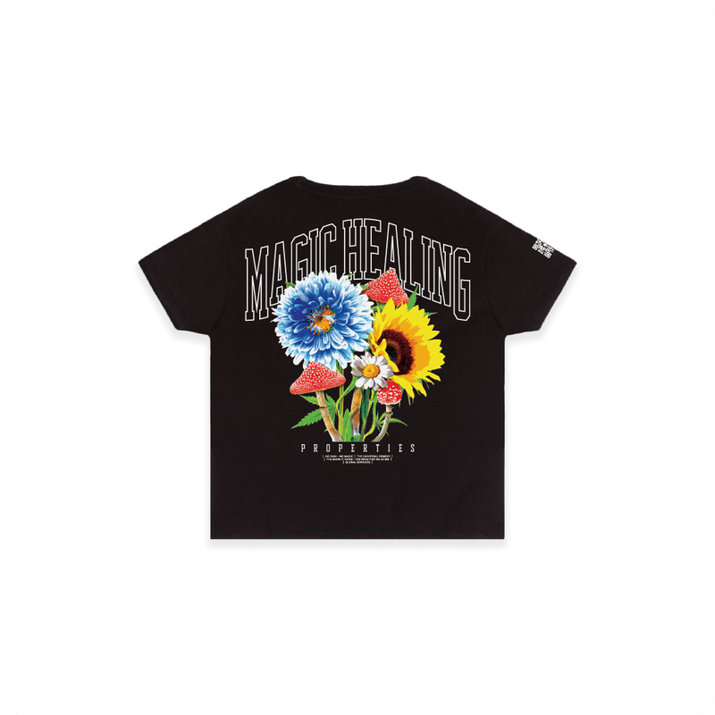 Rear view of a women's black high waisted shirt with flowers psychedelic mushrooms and large white 'MAGIC HEALING' text.