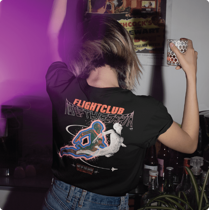 Rear view or a person wearing a black crop top t-shirt with 'Flight Club' design in a bar setting