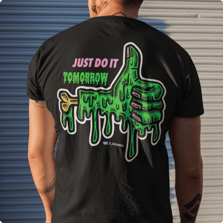 Rear view of a man wearing a black t-shirt with a green slime thumbs up graphic and "Just Do It Tomorrow" text