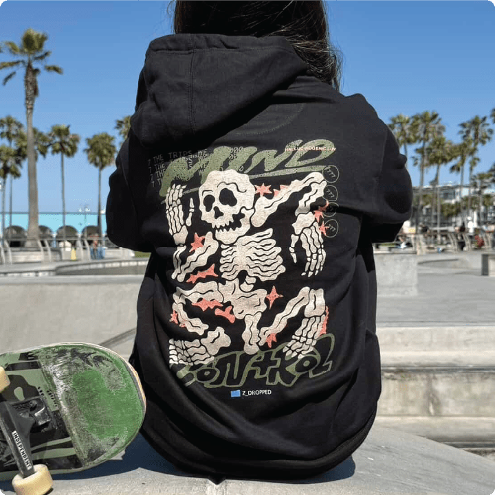 Person wearing a black hoodie with a skeleton design at venice beach skate park.