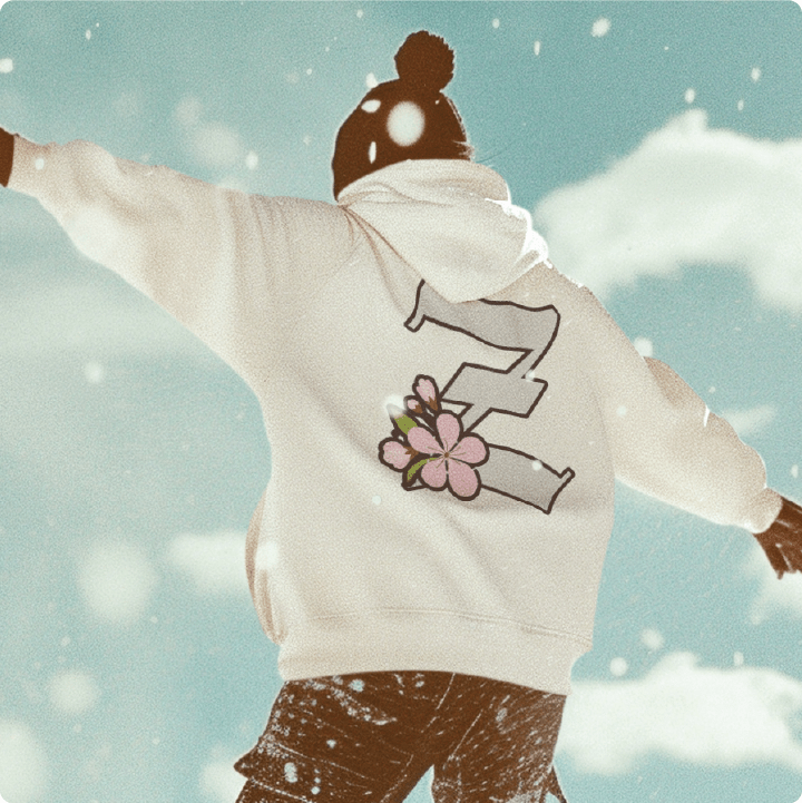 Person wearing a unisex white hoodie with a large Z logo with a cherry blossom on the back snowboarding.