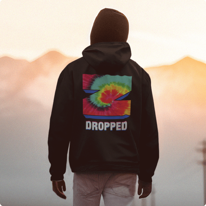 Black hoodie with tie-dye graphic inside the letter 'Z' and 'DROPPED' text on the back, worn by a person skateboarding into the sunset.