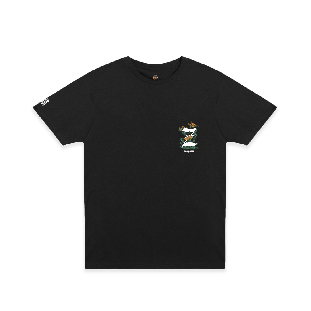 Black t-shirt with a small Z logo and birds of paradise floral elements on the chest against a white background