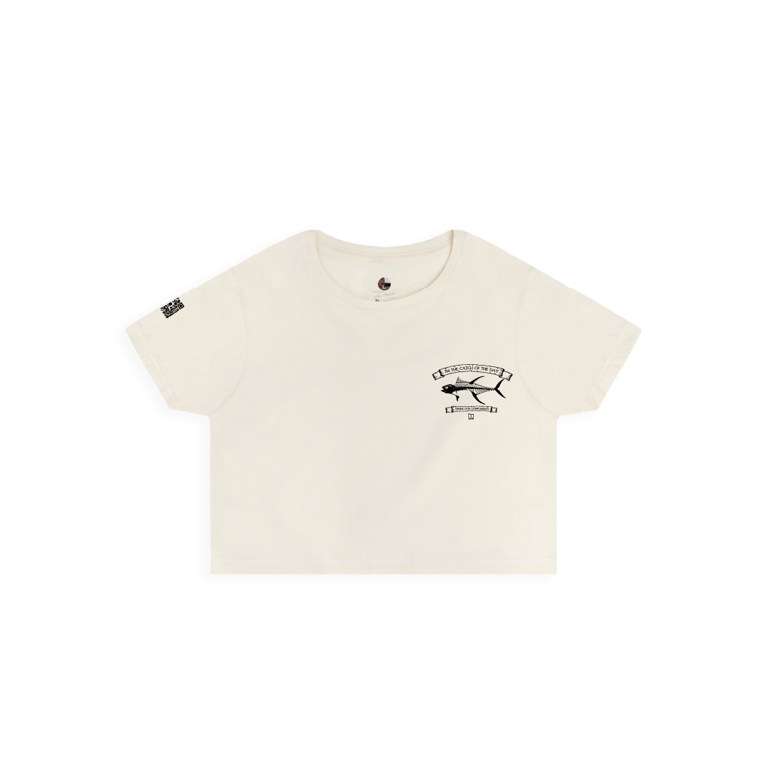 Front view of a womens beige crop top t-shirt with a small black tuna bones fish and 'catch of the day' text on a white background