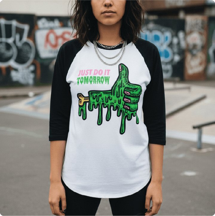 Woman wearing a black and white baseball shirt with a green thumbs up graphic and text in an urban setting.