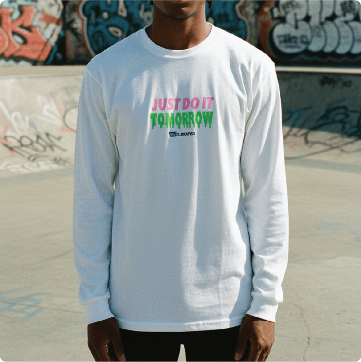 Person wearing a white long-sleeve shirt with 'Just Do It Tomorrow' text in front of a graffiti-covered wall.