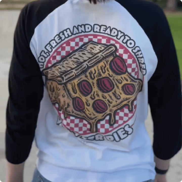 Person wearing a baseball shirt with a pizza graphic and text.