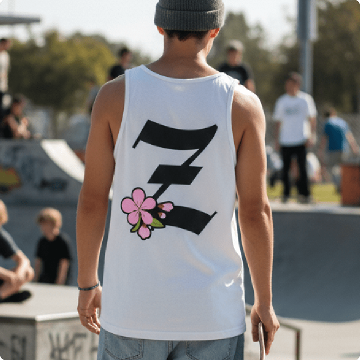 Rear view of a man at a skatepark wearing a white Z_BLOSSOM tank top