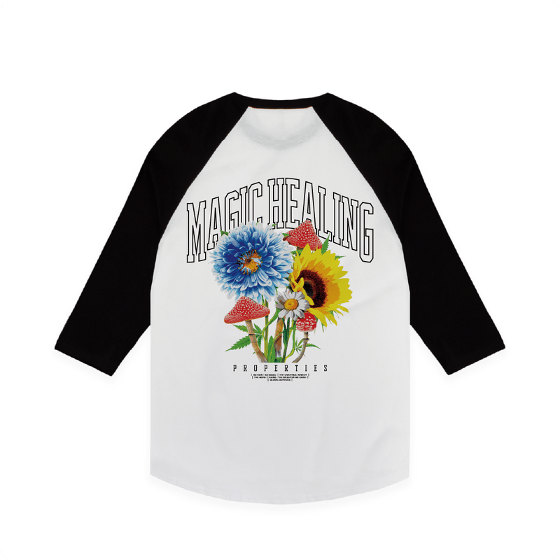 Rear view of a unisex black and white 3/4 sleeve baseball raglan shirt with flowers psychedelic mushrooms and large black 'MAGIC HEALING' text.