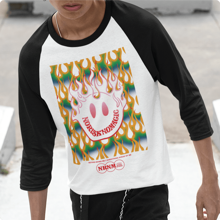 Person wearing a black and white baseball shirt with colorful flaming smiley face graphic on the front