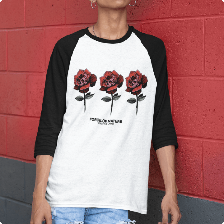 Person wearing a black and white baseball shirt with red rose design against a red brick wall.