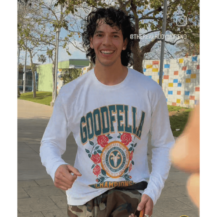 Front view of Rudy Moreno wearing a white long-sleeve shirt with 'Goodfella' design outdoors.