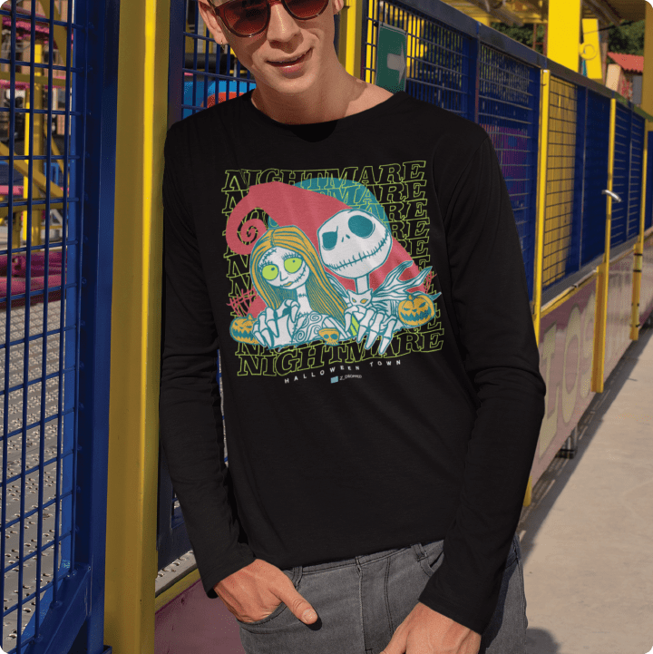 Person wearing a black 'Nightmare' long-sleeve shirt with a colorful graphic design in an outdoor setting.