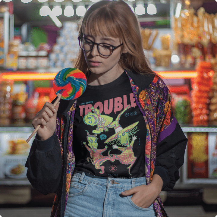Young women wearing a black high waisted tee holding a lollipop at a carnival. 