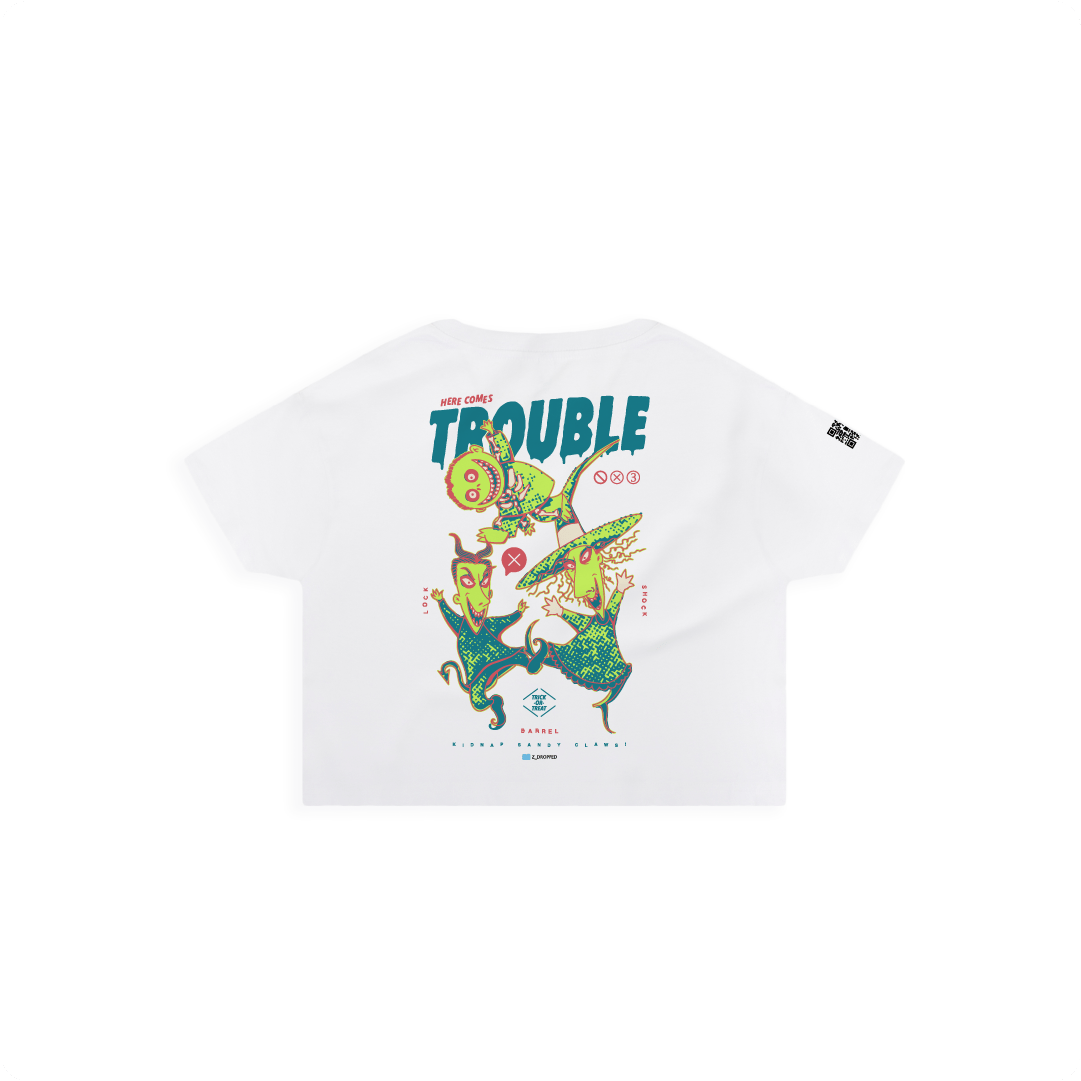 Rear view of a white crop top with colorful lock shock and barrel and 'Here Comes Trouble' text on a white background