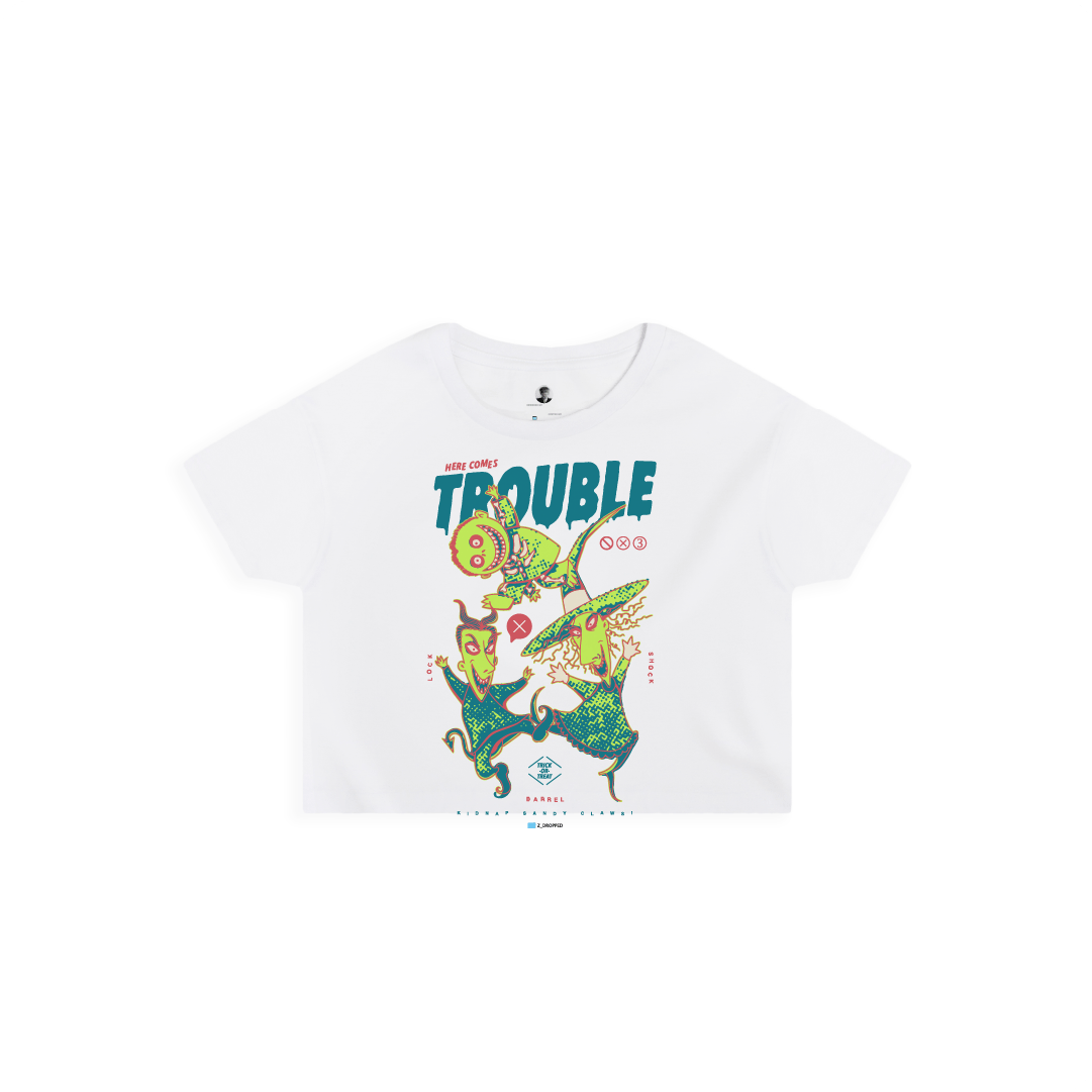 Front view of a white crop top with colorful lock shock and barrel and 'Here Comes Trouble' text on a white background