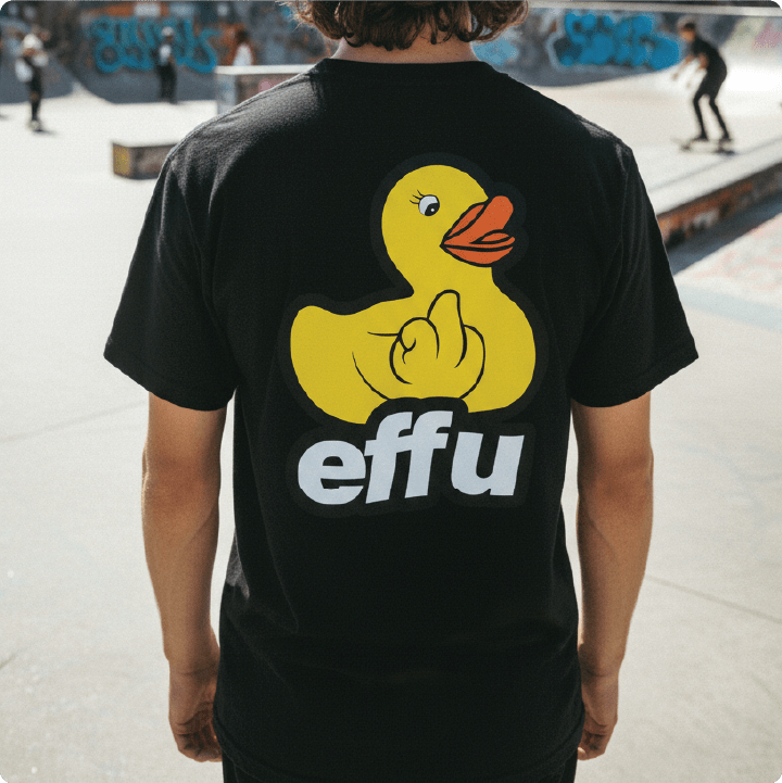 Young man wearing a black t-shirt with a yellow rubber duck and 'effu' text at a skate park.