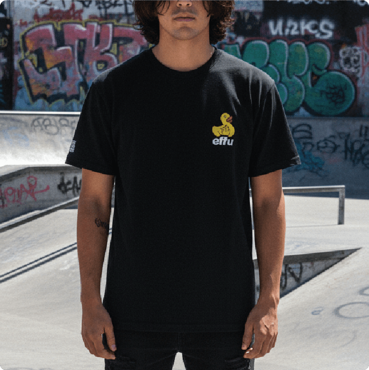 Young man wearing a black t-shirt with a yellow effu rubber ducky at a skate park