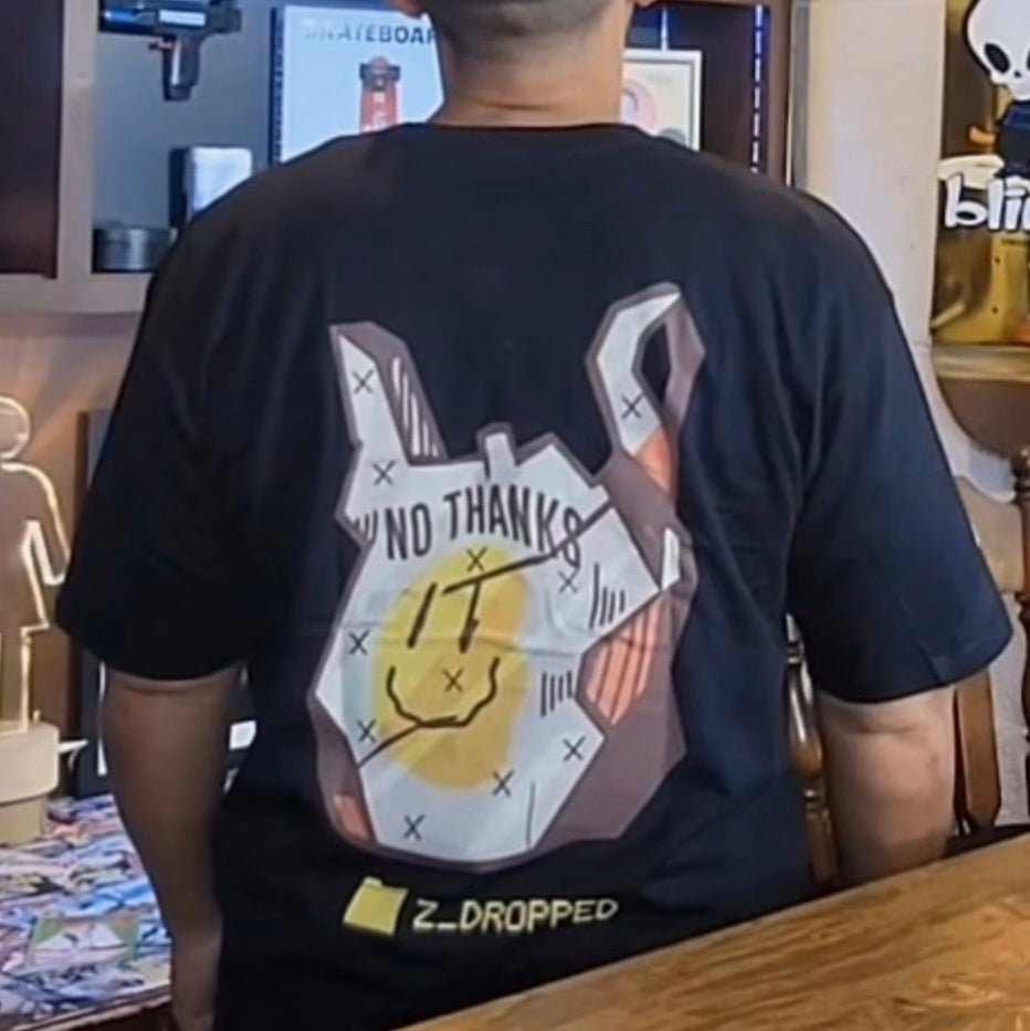 og sk8cho wearing a black no thanks t-shirt with a plastic bag graphic design, standing in front of his podcast.