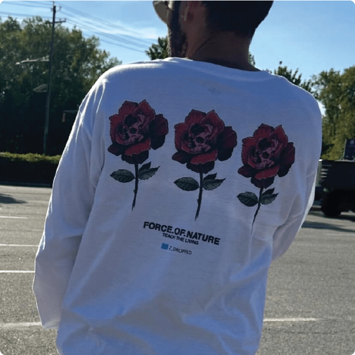 RomieTheKid wearing a white long-sleeve shirt with red skull roses and Force Of Nature text on the back.