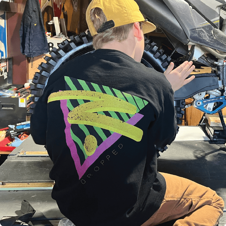 Young boy wearing a black shirt with colorful graphics in a workshop setting