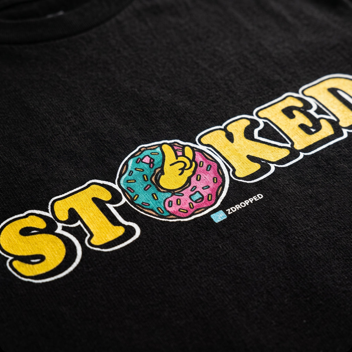zoomed in macro shot of the STOKED tee in black